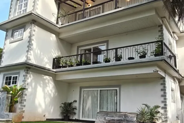 Villa facade and manicured lawn viewed from the garden compound