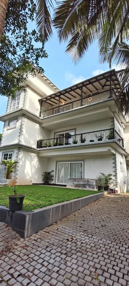 Villa facade and manicured lawn viewed from the garden compound