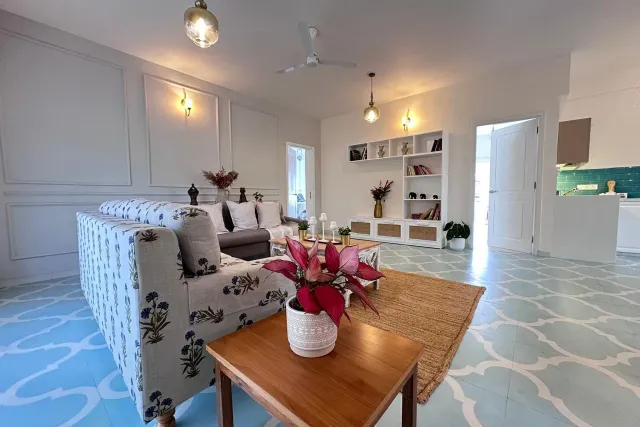 Spacious living room featuring heritage tiled floors, architectural wall panelling, and designer furnishings