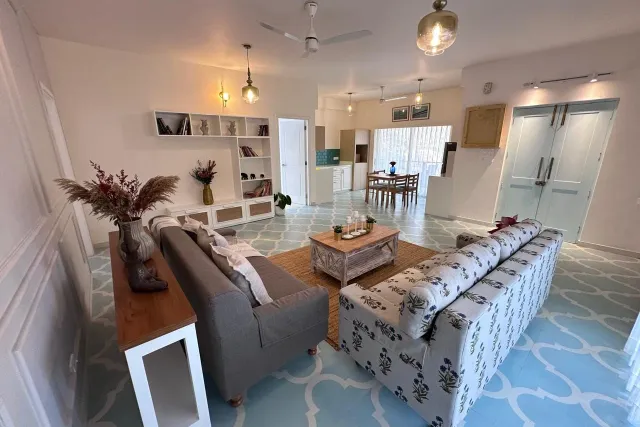 Open-plan living and dining area with four-seater dining suite and warm pendant lighting