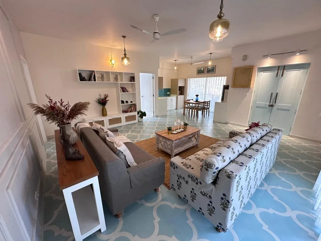 Open-plan living and dining area with four-seater dining suite and warm pendant lighting