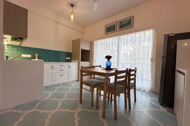 Fully equipped contemporary modular kitchen with subway tile splashback, chimney, and refrigerator