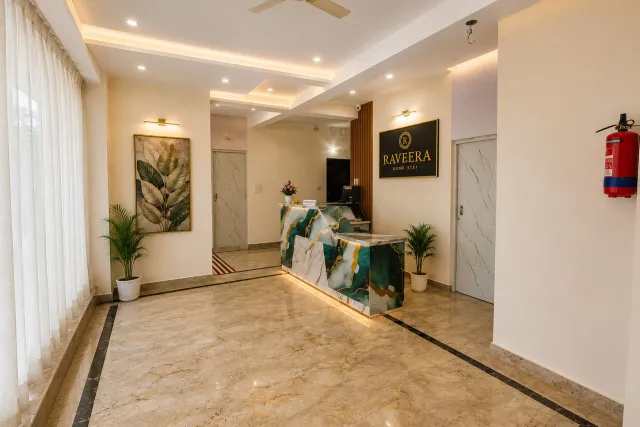 Spacious reception lobby featuring designer marble front desk, illuminated brand signage, and recessed ceiling lighting