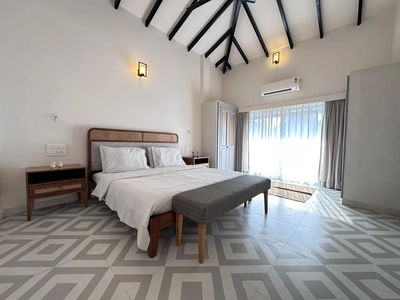 Second double bedroom suite with cane headboard, vaulted ceiling, and sliding glass balcony access