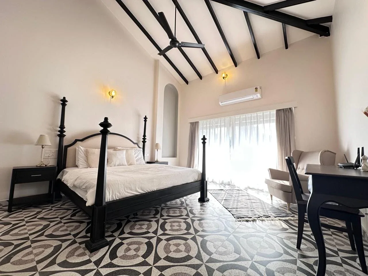 Master bedroom suite with four-poster bed, heritage encaustic tile flooring, study desk, and cathedral ceiling
