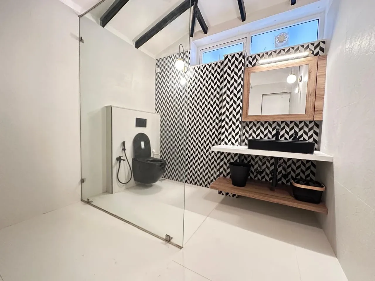 Designer en-suite bathroom with chevron feature tiling, walk-in glass shower, and matte black fixtures