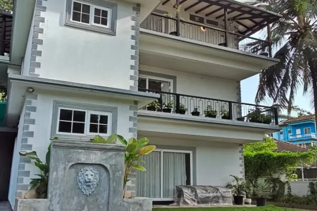 Villa exterior front elevation showcasing the top-floor covered balcony with timber rafters