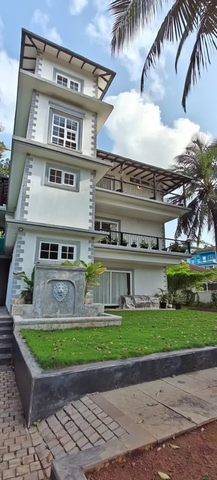 Villa exterior front elevation showcasing the top-floor covered balcony with timber rafters