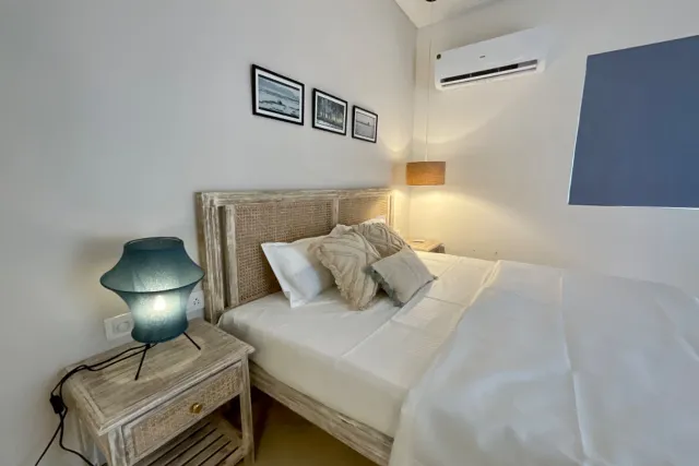 Ground-floor bedroom suite featuring whitewashed cane headboard and nightstands