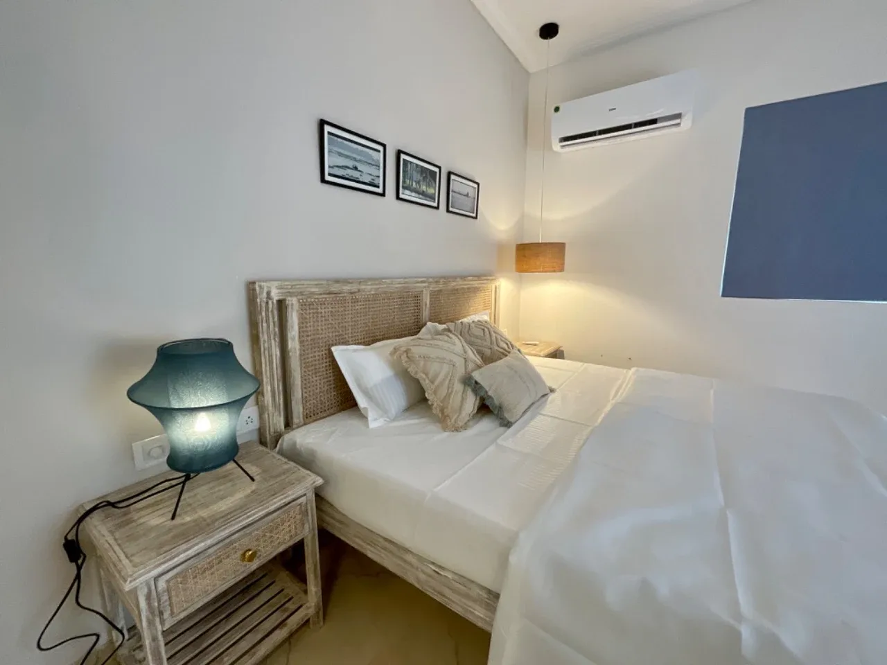Ground-floor bedroom suite featuring whitewashed cane headboard and nightstands