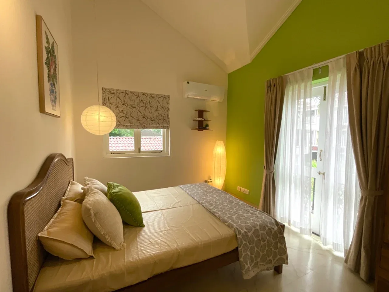 Second bedroom suite featuring high vaulted ceiling, lime green feature wall, and cane bed
