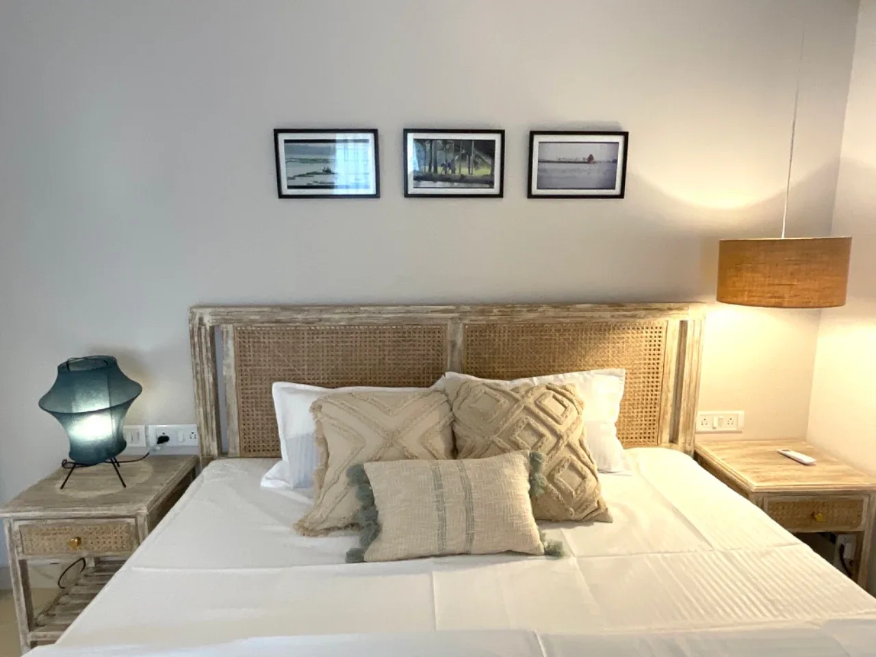 Bedside detail of ground-floor suite with artisanal lighting and framed artwork